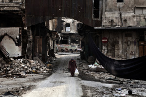Anziana signora siriana attraversa la “via dei cecchini” della città vecchia di Aleppo. ©Fabio Bucciarelli-AFP 